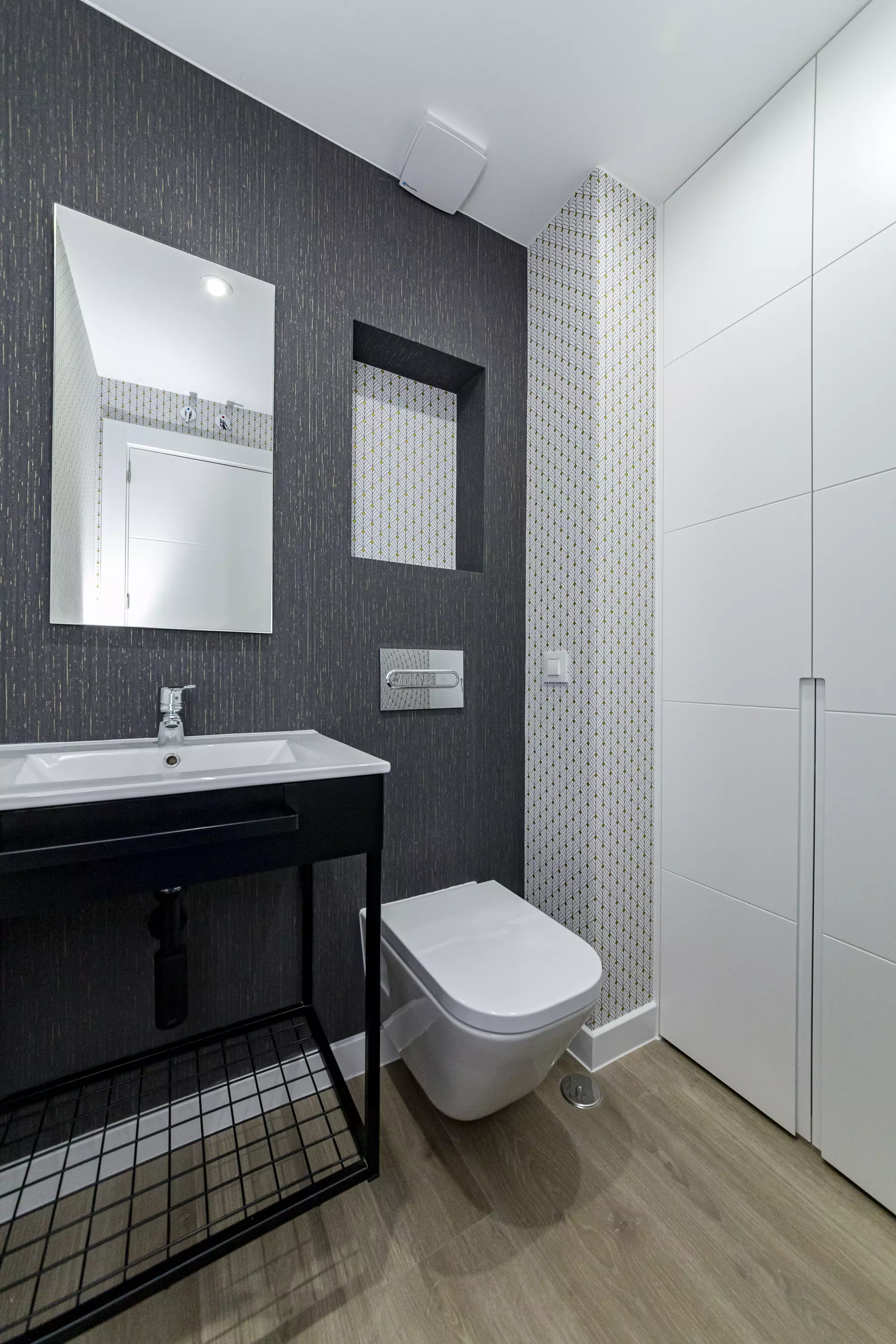 Baño con revestimiento oscuro y lavabo blanco.. Fotografía 4