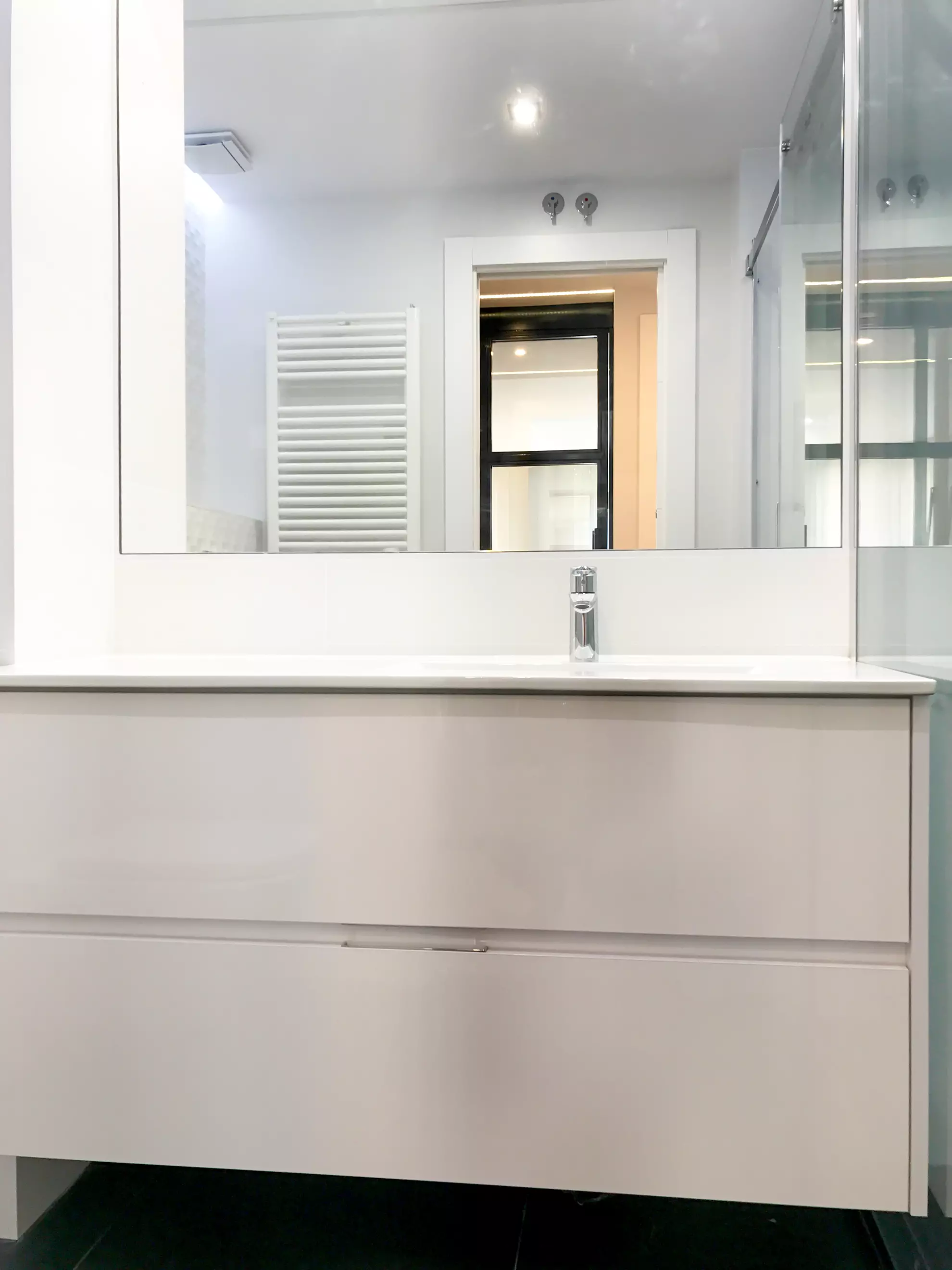 Baño de azulejo blanco con lavabo suspendido y espejo.. Fotografía 7