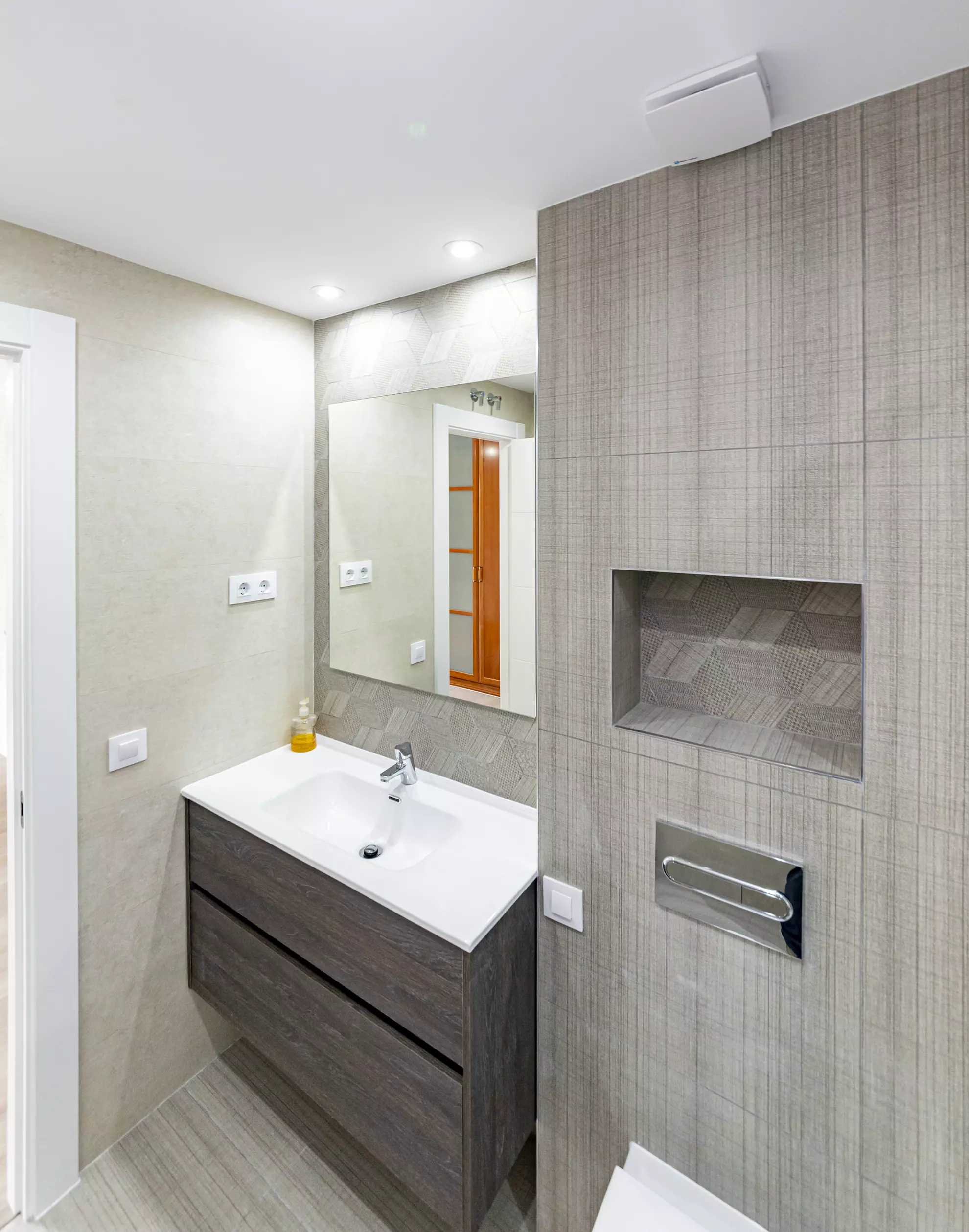 Mueble de lavabo de madera con encimera blanca y espejo.. Fotografía 3