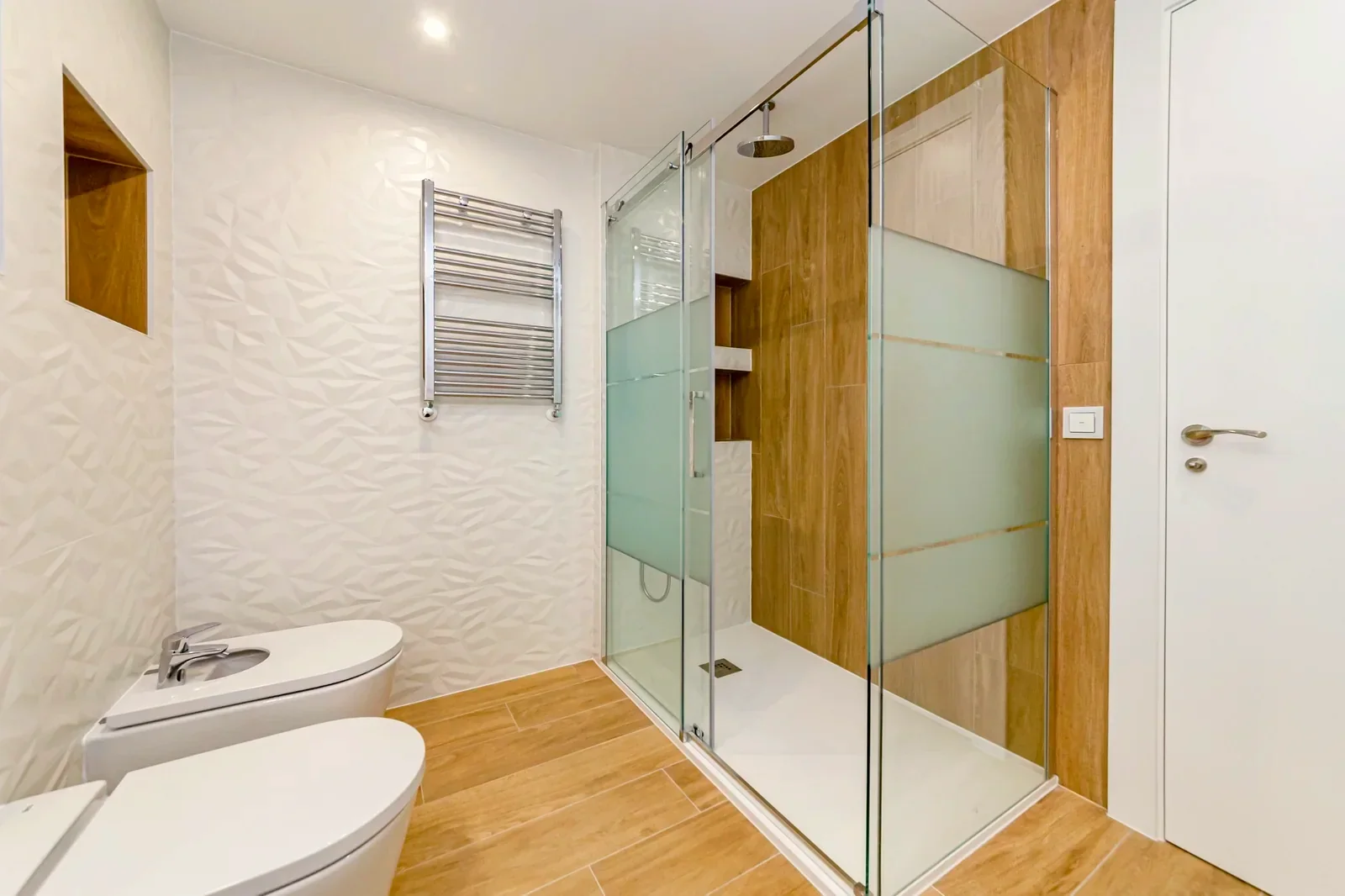 Baño claro con ducha de cristal y mueble de madera.. Fotografía 2