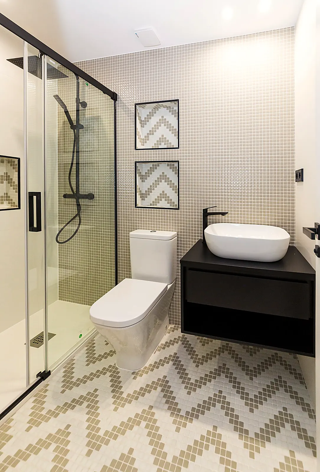 Baño con revestimiento geométrico y mampara negra.. Fotografía 15