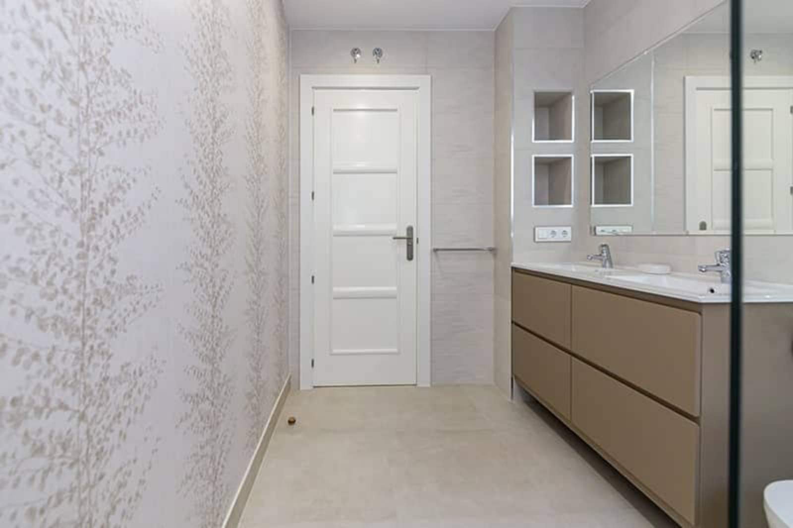 Baño con lavabo sobre mueble de madera y paredes claras.. Fotografía 17