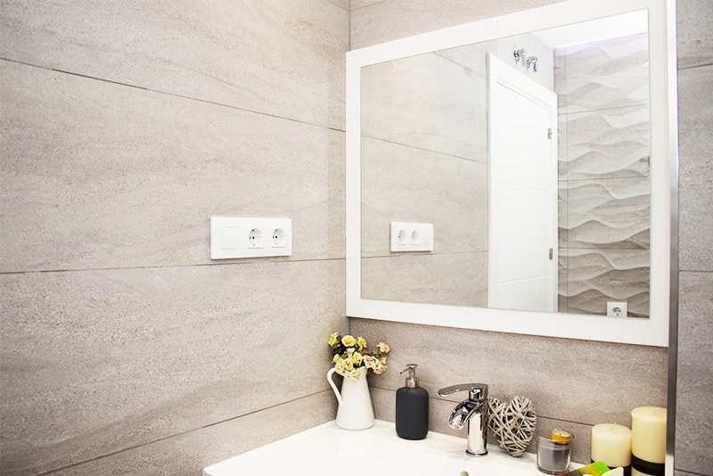 Baño en tonos grises con mueble blanco y espejo rectangular.. Fotografía 11
